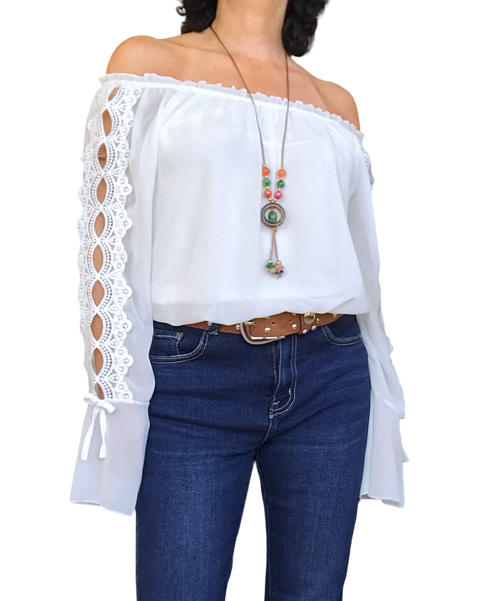 Blouse en voile unie blanche, dentelle le long des manches et volant au bas