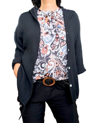 Chemise noire, texturée à capuchon, manches longues avec camisole blanche, imprimé floral noire, noisette, et bleu ciel nouée au cou